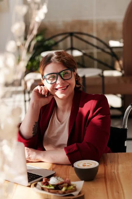 pexels-photo-4063616-4063616 Smiling woman in red blazer working on laptop with coffee and meal at café.